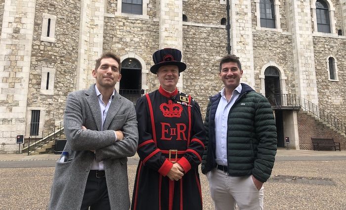 men standing with beefeater at the tower of london