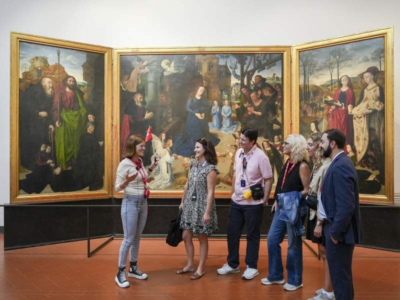 A group of tourists in front of the Portinari Triptych at the Uffizi Gallery while on tour with The Tour Guy.