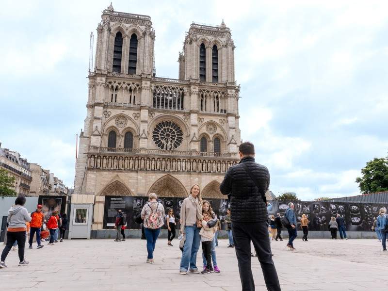 Tourists taking a picture in front of Notre-Dame in Paris. 