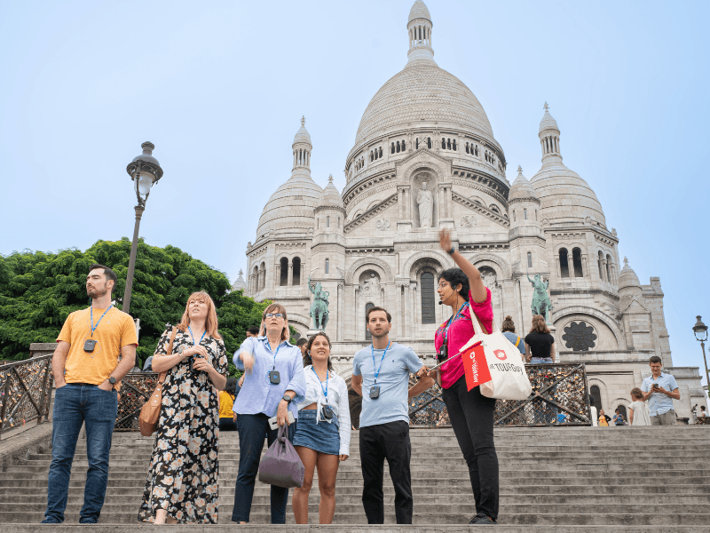 A group of tourists in Montmartre/Paris in front of the Basilica of Sacre Coeur with a guide from The Tour Guy.