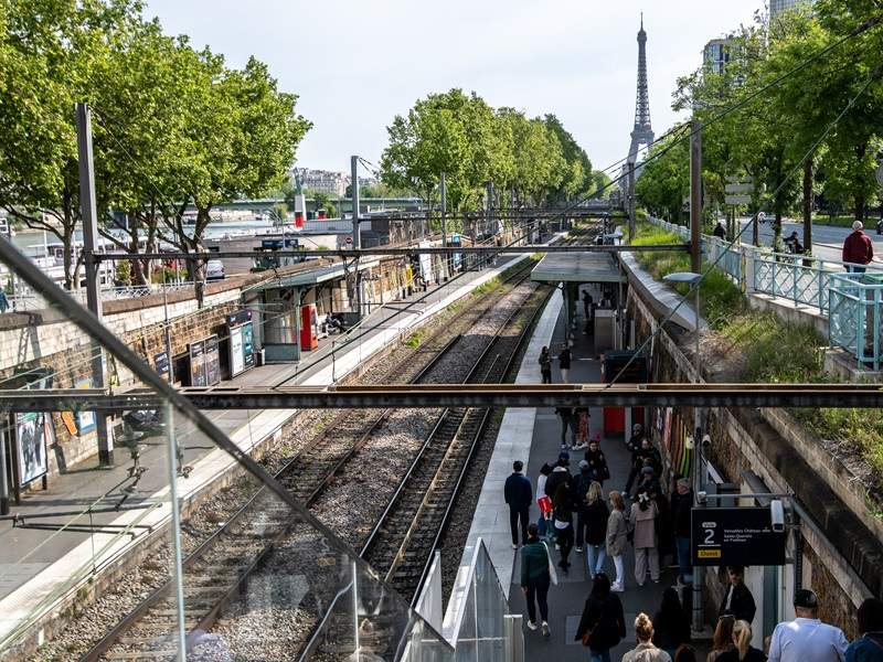 A picture of a metro station in Paris with the Eiffel Tower in the background. 