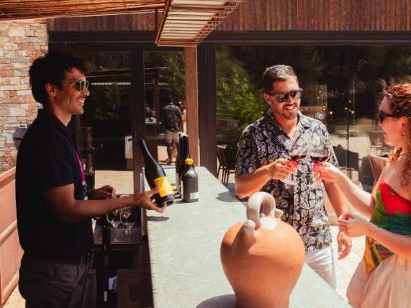 Tour guide showing bottle of wine to woman