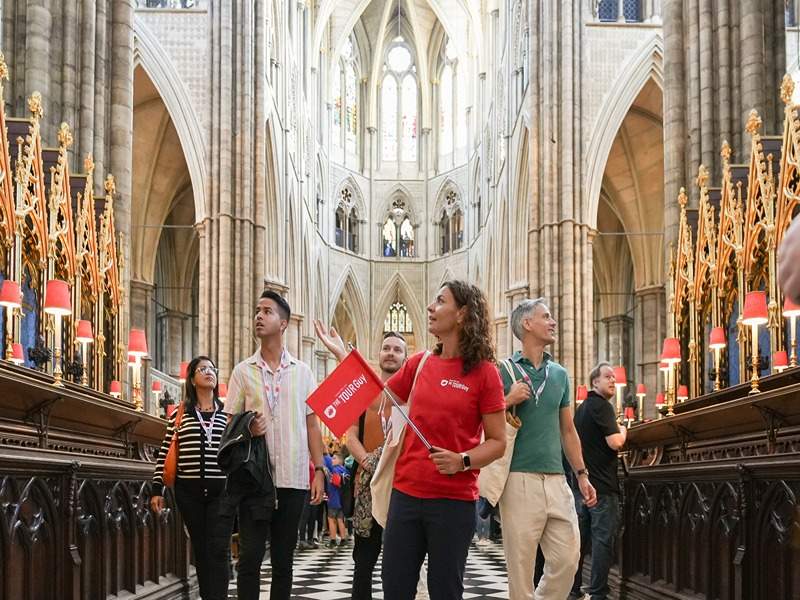 A group of tourists inside Westminster Abbey with a guide from The Tour Guy.