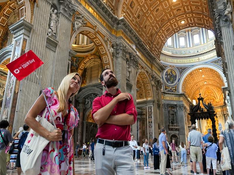 A tourist inside St. Peter's Basilica with their guide from The Tour Guy.