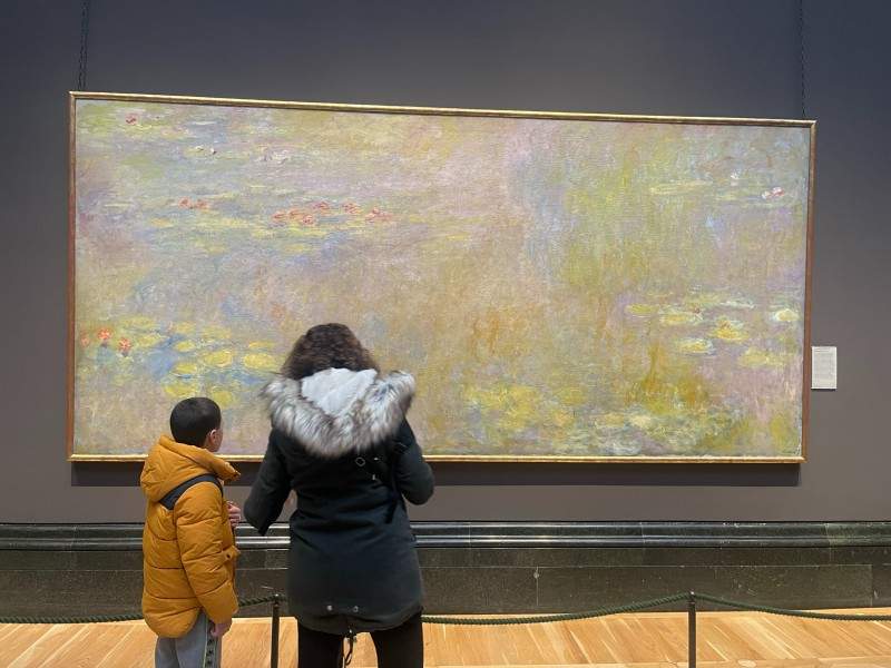 A mother and son looking at Monet's Water Lilies in the National Gallery, London.