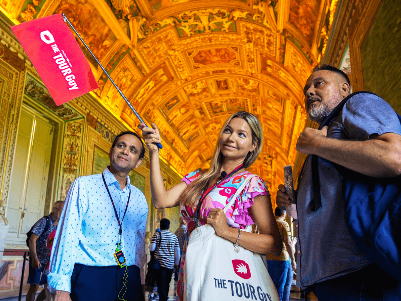 A group of tourists inside the Hall of Tapestries with their guide from The Tour Guy.