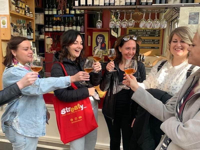 Happy People drinking wine with guide inside Mercato Testaccio