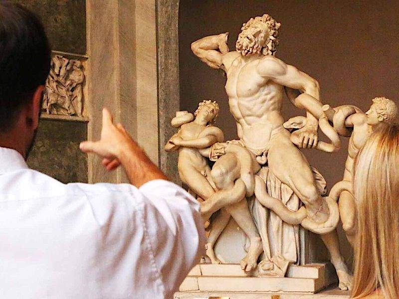 Tourists looking at Lacoon and His Sons inside the Vatican Museums.