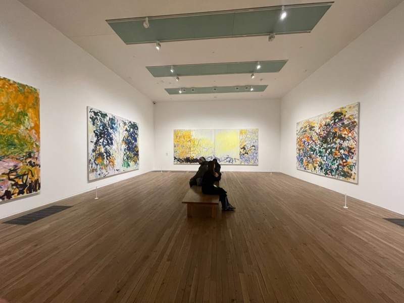 People sitting in an exhibit room in the Tate Modern in London.