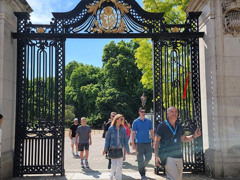 A group of tourists walking into Buckingham Palace with their guide from The Tour Guy.