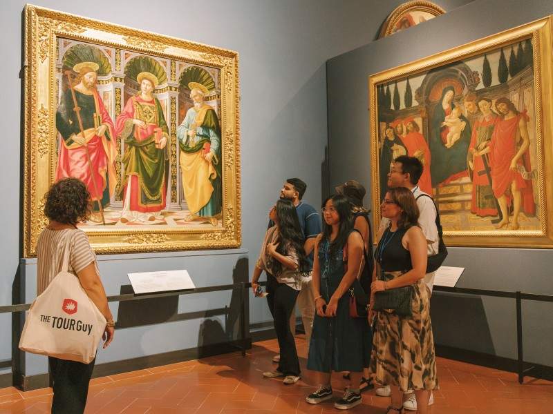 A group of tourists waking through the Accademia Gallery with their guide from The Tour Guy.