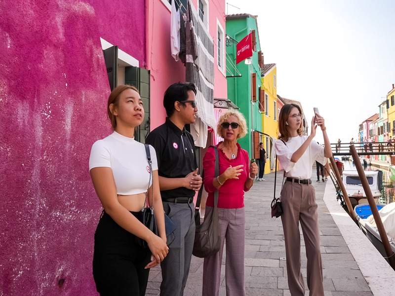 Tourists in Burano Island while listening to their guide from The Tour Guy.