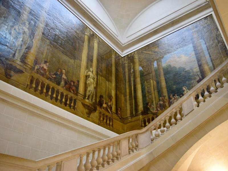 A stairwell with a wall mural in the Musee Carnavalet in Paris.