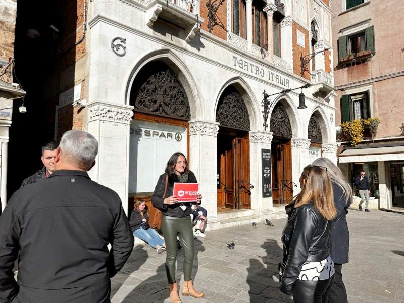 A group of tourists in front of Despar Teatro Italia with a guide from The Tour Guy.