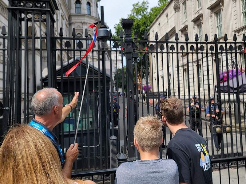 A group of tourists looking at 10 Downing Street while on tour with The Tour Guy.