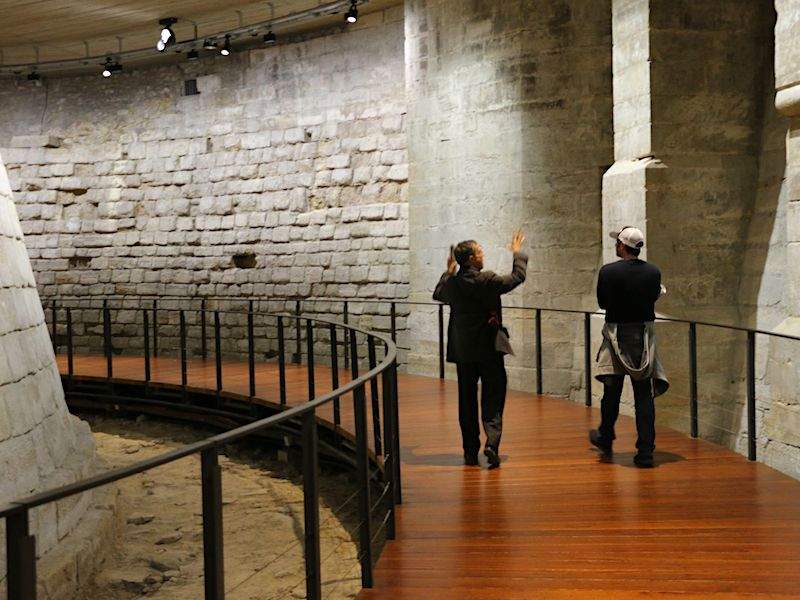 A tourist walking through the Medieval Louvre, the ruins of the Château du Louvre.