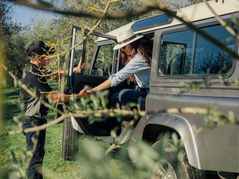 Woman getting out of jeep with aid of driver