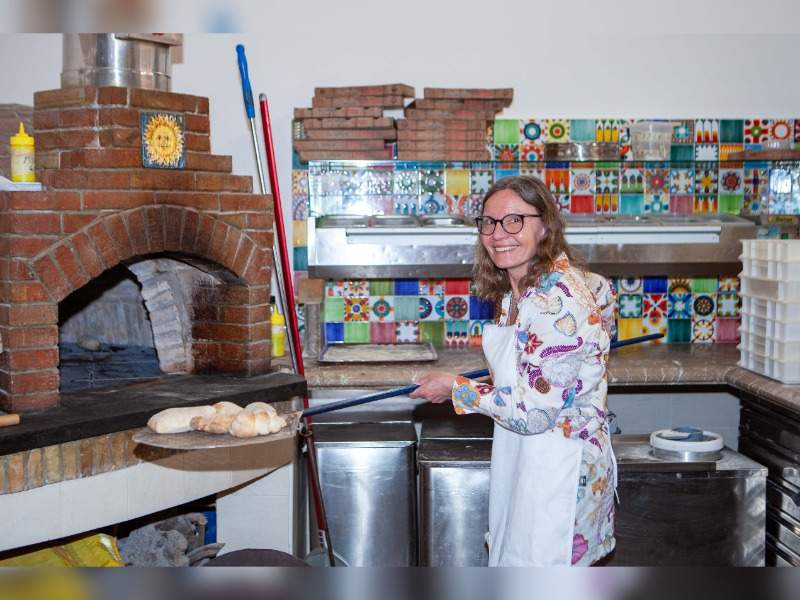 woman with brick oven pizza