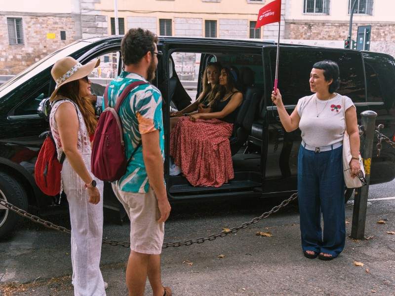 A tourist meeting their tour guide before entering a van with The Tour Guy.