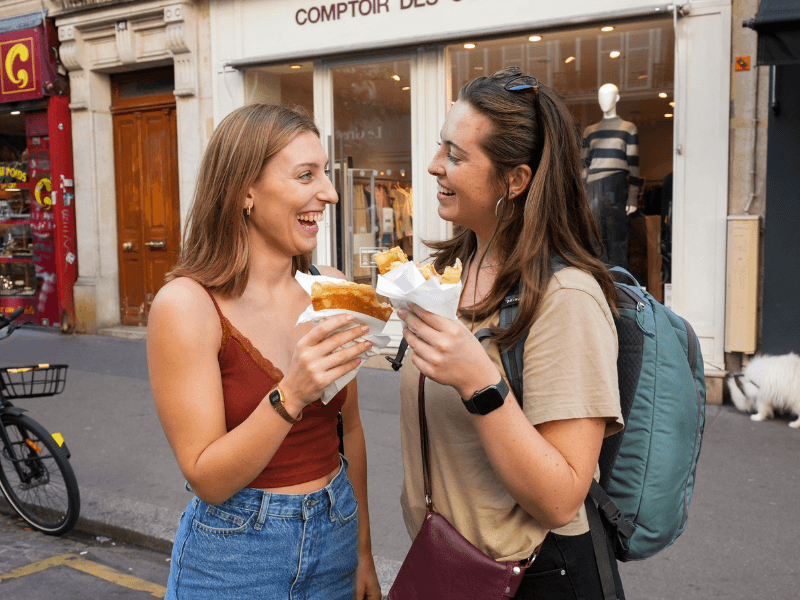 Two friends enjoying a crepe while on a food tour in Paris with The Tour Guy.