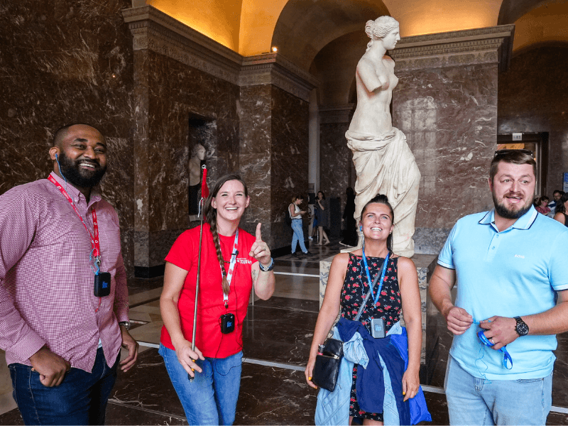 A group of tourists inside the Louvre Museum with their guide from The Tour Guy.