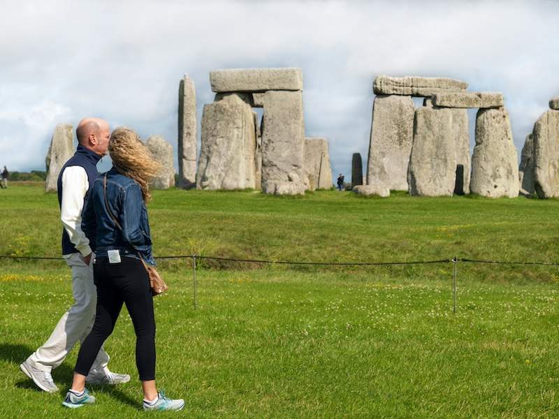 Couple walking with Stonehenge behind