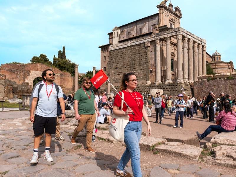 A group of tourists walking past the Temple of Julius Caesar with their guide from The Tour Guy.