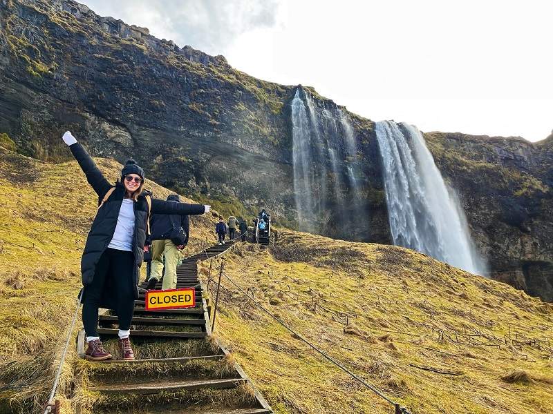 woman on stairs at Seljalandsfoss waterfall