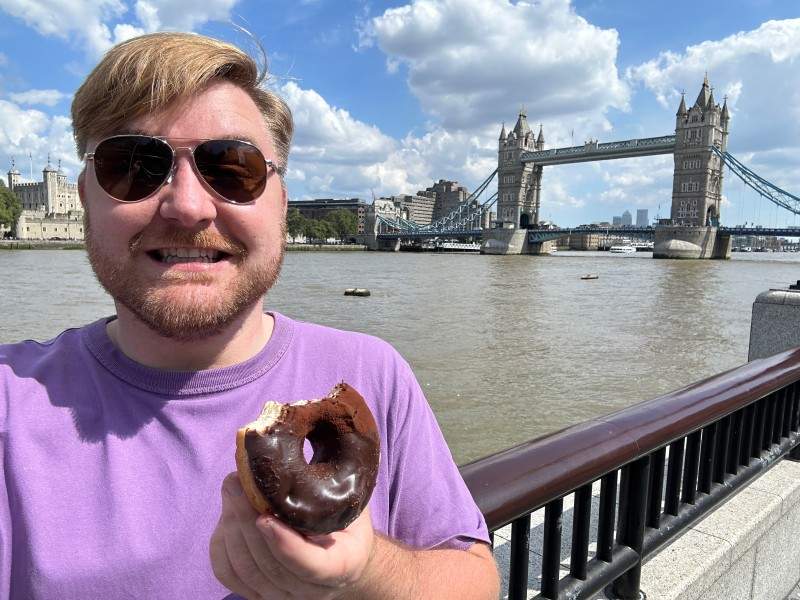 People holding donuts with Tower Bridge