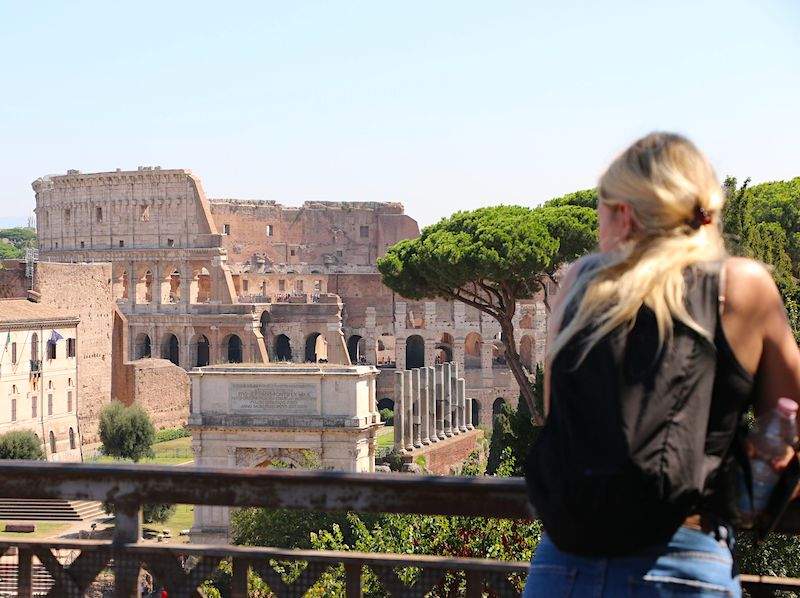 A woman looking at the Colosseum.