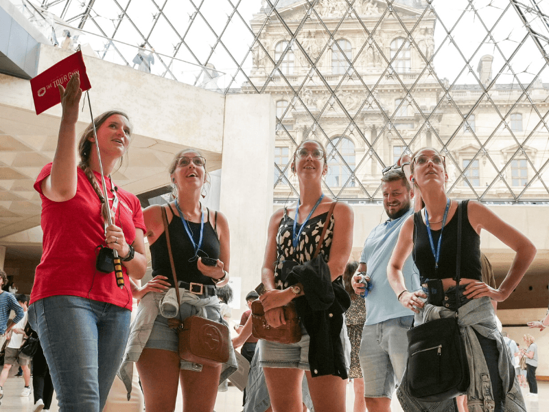 A group inside the Louvre Museum listening to their guide from The Tour Guy.