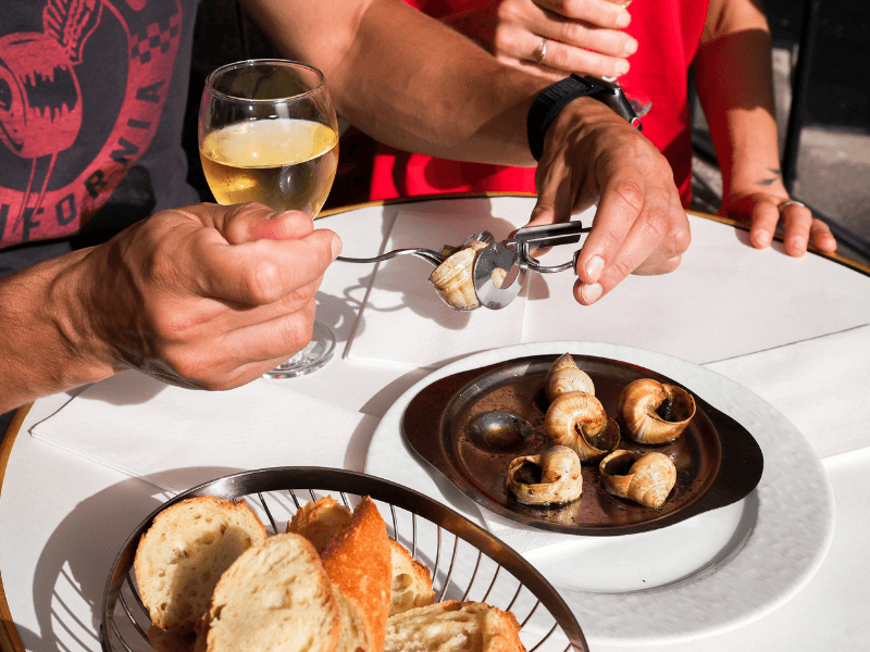 A tourist eating escargot in Paris.