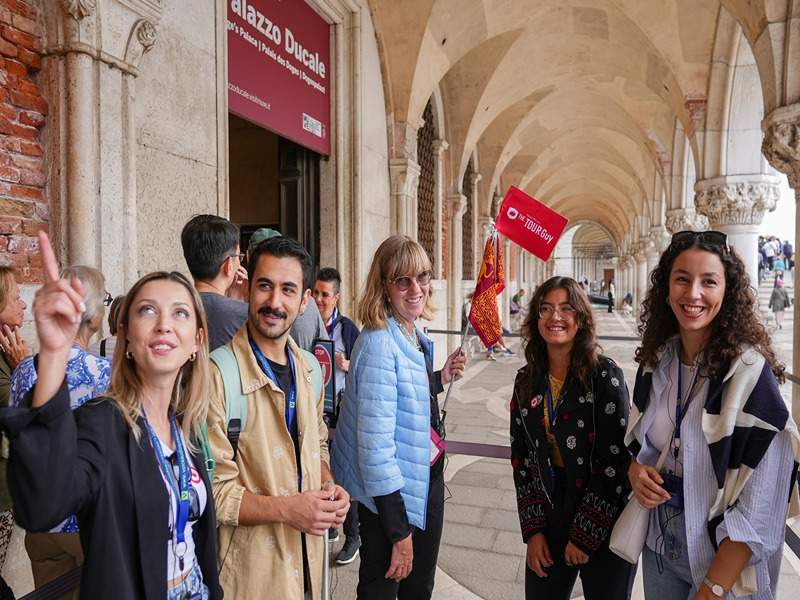 A group of tourists in line to enter the Doge's Palace in Venice with their guide from The Tour Guy.