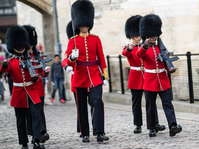 An image of a group of British Royal Guards walking through the Tower of London.