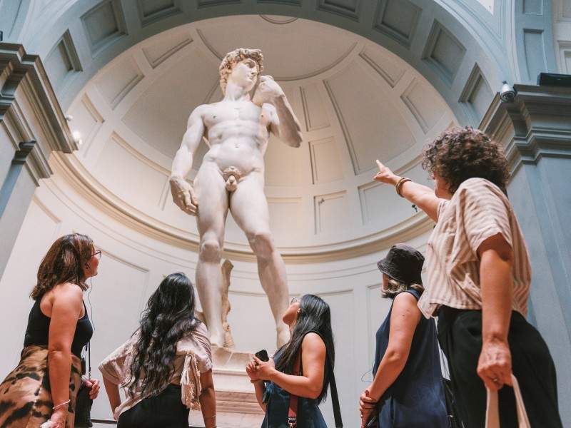 A group of tourists in front of the Statue of David inside of the Accademia Gallery while on tour with The Tour Guy.