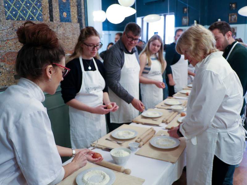 people making pasta in a kitchen