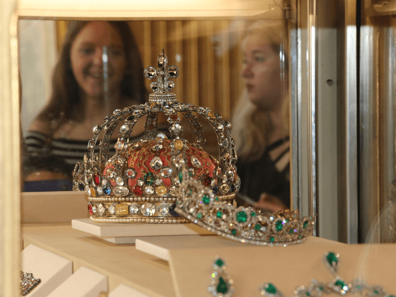 Tourists looking at the French Crown Jewels on display in the Louvre Museum.