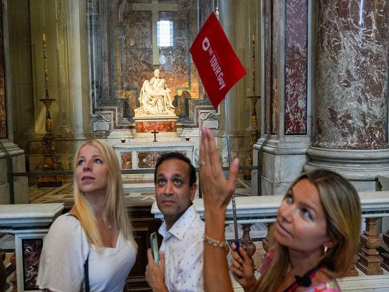 A pair of tourists in front of Michelangelo's La Pieta with their guide from The Tour Guy.