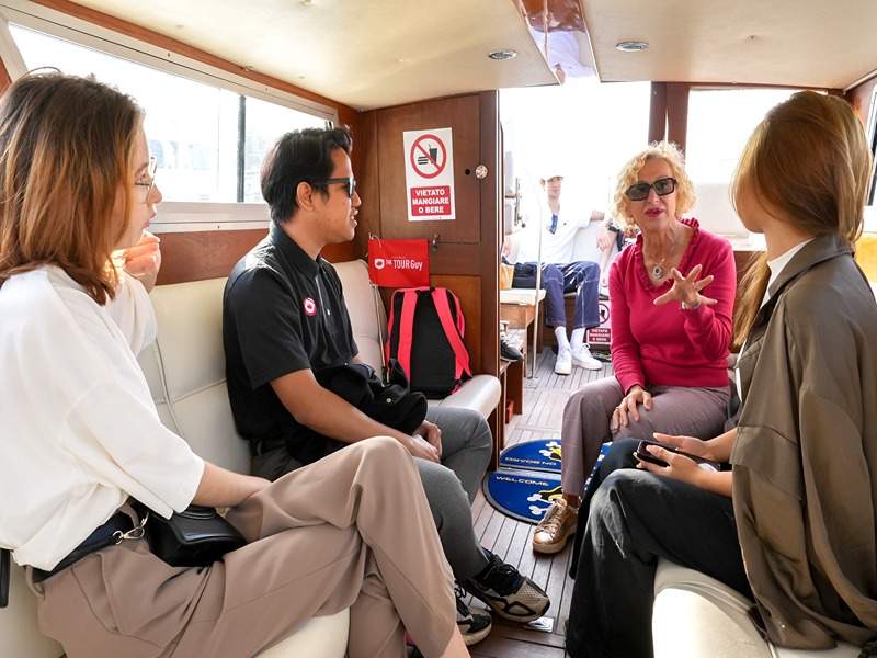 A tour group on a boat with their guide from The Tour Guy.