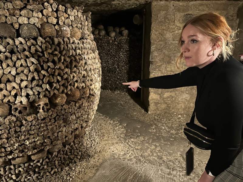 Girl pointing the barrel of passion at catacombs in Paris