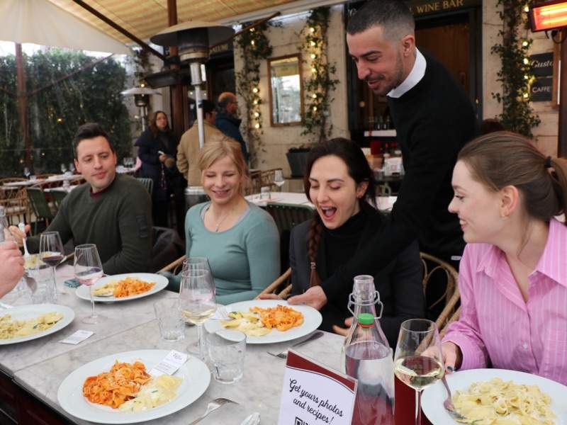 A group of tourists eating pasta in a restaurant in Rome.