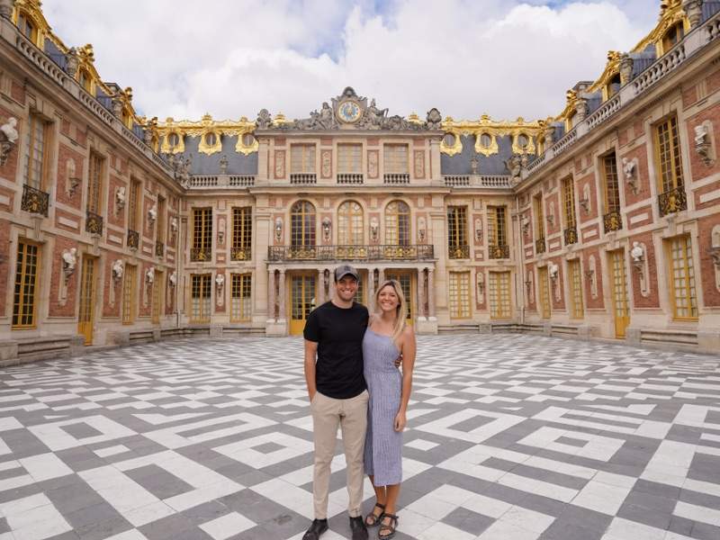 Couple posing in front of the Palace of Versailles