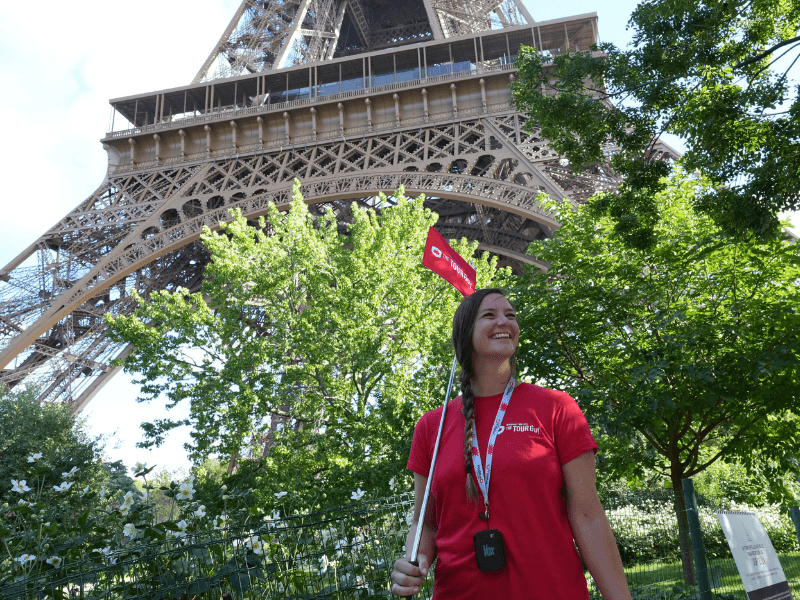 A tour guide standing in front of the Eiffel Tower in Paris.