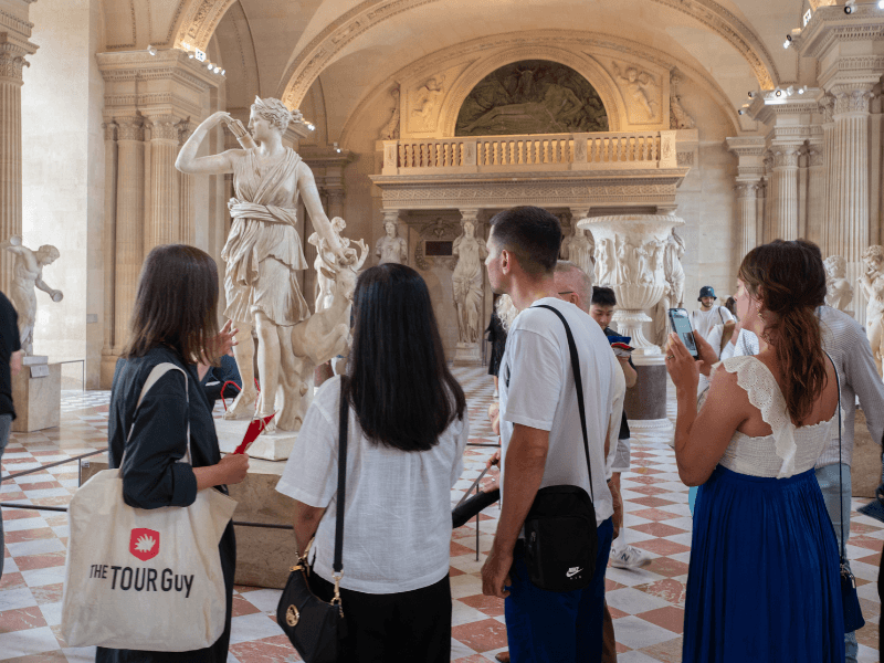 Tourists inside the Louvre Museum with their guide from The Tour Guy.