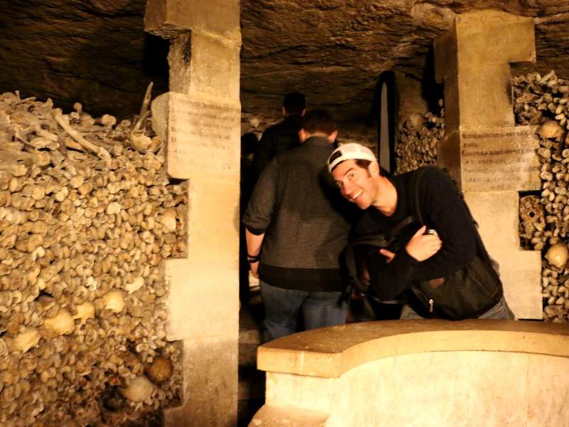 Man smiling at catacombs in Paris