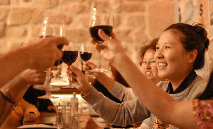 happy people drinking wine on paris food tour
