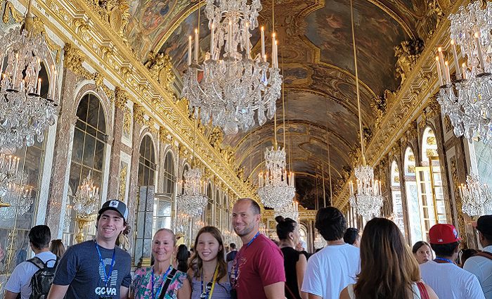 family taking picture in hall of mirrors