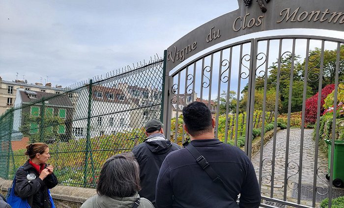 people at the gate of the vignes du close vineyard in montmartre