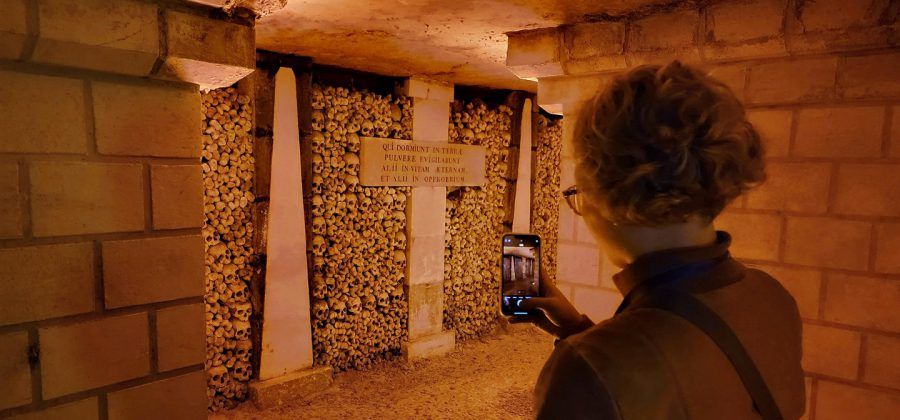 Women taking photo in the Paris Catacombs.