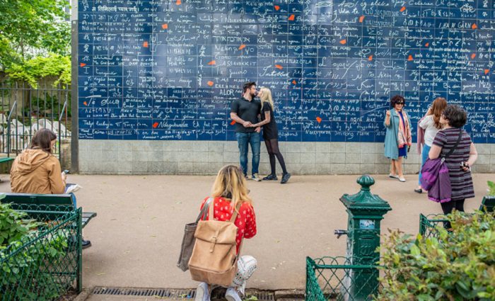 people kissing at the wall of love